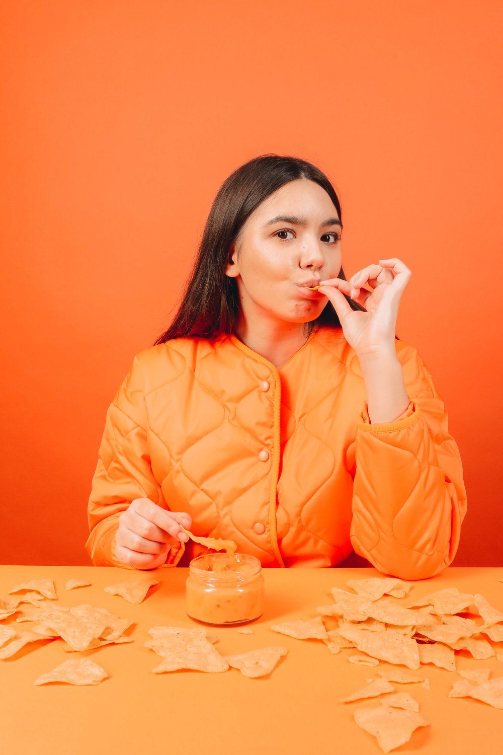 Woman Eating Nachos with Cheese Sauce